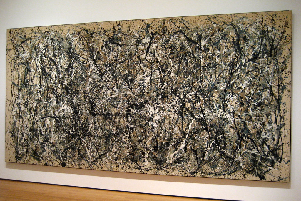 A large abstract black-line painting hung on a cream gallery wall above a bench